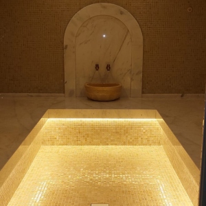 Турецкая баня в отделке из мозайки нежного бежевого цвета.